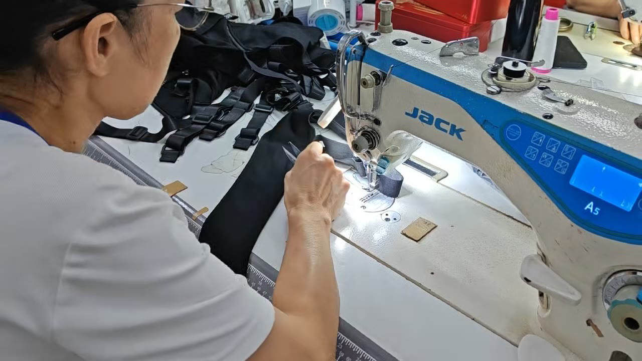Operator sewing a black garment panel